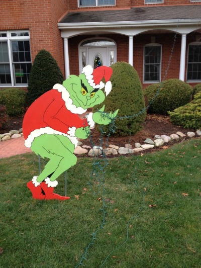 giant grinch stealing lights off house